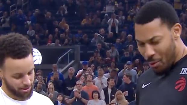 Golden State Warriors star Stephen Curry presents Toronto Raptors forward Otto Porter Jr. with a 2022 championship ring.